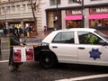 Protester holds sign in front of SFPD car