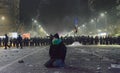 Protester knees during protests against government in Bucharest