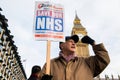 Protester with placard/banner at the Save Our NHS protest demonstration - London.