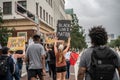 Black lives matter protester walks down the street holding a sign