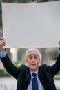 Protesting businessman holding a blank white posterboard over his head Royalty Free Stock Photo