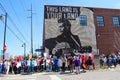 Protestors march by Woody Guthrie Mural that says This Machine Kills Fascists at March for Life protest in Tulsa Oklahoma 2 24 201