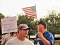 Protestors with signs and American flag