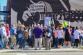 Protestors walk past Wood Guthrie mural that says This Machine Kills Fascists n Tulsa Oklahom USA 3 24 2018