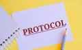 PROTOCOL word written on white paper. Protocol concept, with a focus on the expected gains, a standard set of rules