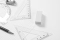 Protractor, rulers, pencil and eraser on squared paper Royalty Free Stock Photo