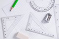Protractor, rulers, pencil and eraser on squared paper Royalty Free Stock Photo