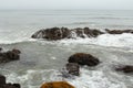 Protruding rocks from the water of the Pacific ocean at low tide. Royalty Free Stock Photo