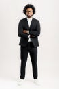 Proud african-american male businessman in black suit standing with arms crossed isolated on white Royalty Free Stock Photo