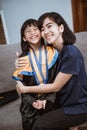proud asian mother embrace her daughter during elementary school graduation day