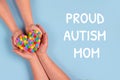 Proud Autism Mom and World Autism Awareness Day concept - autistic child& x27;s hands supported by mother holding