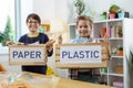 Proud beaming students showing boxes filled with separated trash