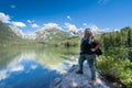 Proud blonde woman hiker stands on a rock on the shoreline of Taggart Lake, in Grand Teton National Park Royalty Free Stock Photo