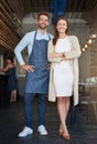 Proud business partners. Portrait of two young business owners standing in their cafe.