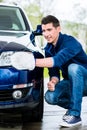 Proud car owner cleaning the headlamps Royalty Free Stock Photo