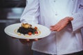 Proud chef holding a plate of squid ink spaghetti Royalty Free Stock Photo