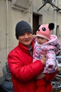 Proud Chinese grandfather with bundled winter baby