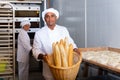 Hispanic baker showing fresh baked baguettes in bakery Royalty Free Stock Photo