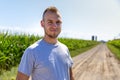 Proud farmer looking at the camera in a corn field