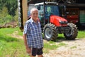 Proud farmer standing in front of his tractor