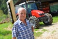 Proud farmer standing in front of his tractor