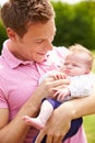 Proud Father Holding Baby Daughter In Garden