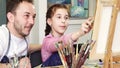 Proud father watching his lovely daughter painting a picture Royalty Free Stock Photo