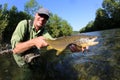 Proud fisherman holding brown trout