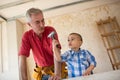 Proud grandfather watching his grandson in the workshop