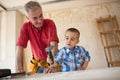 Proud grandfather watching his grandson in the workshop