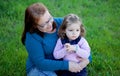 Proud grandmother with her granddaughter sitting on the grass