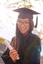 Proud of her achievment. Portrait of a beautiful student holding her graduation certificate.