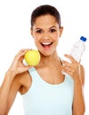 Proud of her healthy lifestyle. Portrait of a happy young woman holding an apple and a bottle of water. Royalty Free Stock Photo