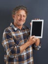 Proud of his new gadget. A portrait of a happy mature man showing a tablet with a blank screen. Royalty Free Stock Photo