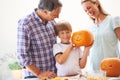 Proud of his pumpkin carving. Portrait of a little boy holding his jack-o-lantern with hi parents on either side of him. Royalty Free Stock Photo