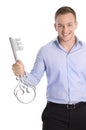 Proud isolated business man holding a key for a new house in his Royalty Free Stock Photo