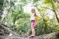 Proud little girl scout standing on a log in the woods