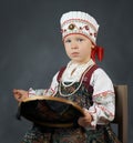 Proud little girl in the traditional russian sarafan during embroidering