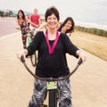 Proud mother and her three happy children on bicycles