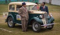 Proud owner stands beside his Austin Seven 1938 model vintage car at the Statesman Vintage Car Rally.