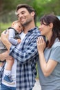 proud parents holding baby daughter in garden Royalty Free Stock Photo