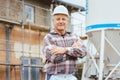 Proud plasterer standing in front of scaffold on construction site