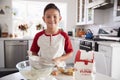 Proud pre-teen boy making cake mixture on his own in the kitchen, smiling, close up