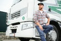 Proud Professional Trucker Standing in Front of His Truck. Trucking and Transportation Theme. Royalty Free Stock Photo