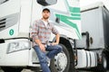 Proud Professional Trucker Standing in Front of His Truck. Trucking and Transportation Theme. Royalty Free Stock Photo