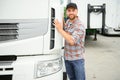 Proud Professional Trucker Standing in Front of His Truck. Trucking and Transportation Theme. Royalty Free Stock Photo