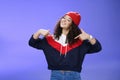 Proud and self-satisfied happy young energized stylish female model in warm beanie brag about own achievements as Royalty Free Stock Photo