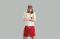 Funny nerd in gym shorts, tank top, headband and glasses pretending to be tough guy