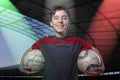 Proud, smiling teenage boy holding two soccer ball's