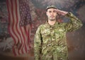 Proud soldier saluting against fluttering american flag and fireworks in background Royalty Free Stock Photo